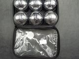 a black case filled with silver balls and a green handle