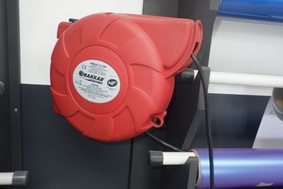 une borne d'incendie rouge fixée sur le côté d'un mur