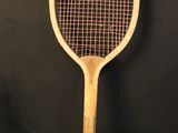 a wooden tennis racket on a black background