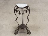 a metal stand with a marble top on top of it