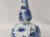 a blue and white vase sitting on a white surface