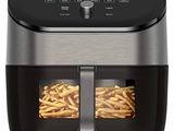 une friteuse à air chaud noire et argentée contenant des frites