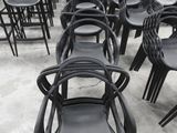 des rangées de chaises en plastique noir dans un entrepôt qui en regorge