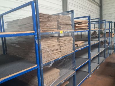 de nombreuses étagères sur lesquelles sont empilés des tas de bois, dans un entrepôt