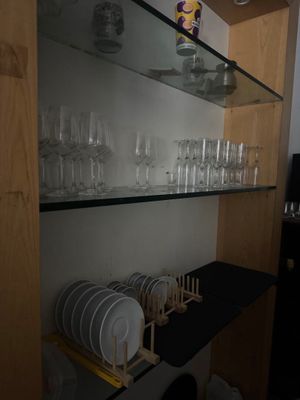 de nombreux verres et assiettes sur les étagères de la cuisine
