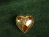 gold heart shaped brooch on a green velvet background