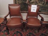 deux chaises en cuir marron posées sur un tapis devant un tableau