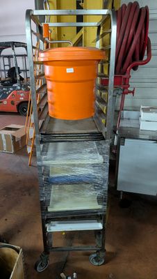 a large orange bucket sitting on top of a metal cart