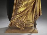 statue of a woman dressed in gold with a sword and shield