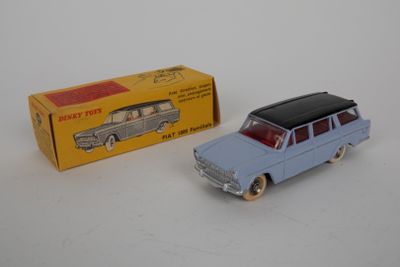 une petite voiture et une boîte posées sur une surface blanche