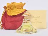 un petit flacon de parfum posé à côté d'un sac rouge