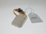 a gold ring with a black stone on it and a price tag