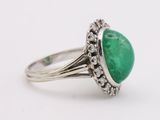 a close up of a ring with a green stone in it