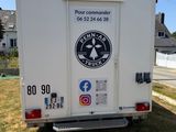 un camion blanc garé sur le bord de la route