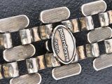 a close up of a metal bracelet with a silver buckle