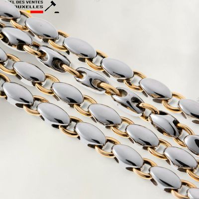 un gros plan sur une chaîne en or et en argent aux maillons ovales