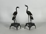 une paire de grues en bronze sur des socles
