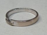 une bague en argent ornée d'une croix, posée sur une table
