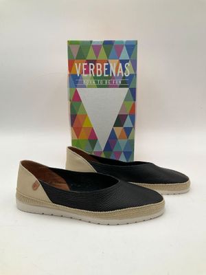 une paire de chaussures noires et blanches avec une boîte de verveines