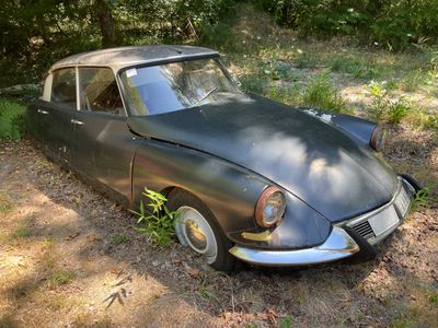 une vieille voiture abandonnée dans l'herbe