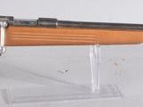 fusil exposé sur un socle en acrylique transparent posé sur une surface blanche