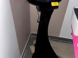 une table noire avec un plateau noir et une chaise rose