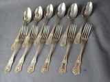 six spoons and six forks are lined up on a table
