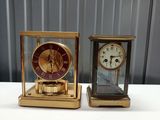 two clocks sitting side by side on a table