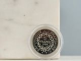 a silver coin sitting on top of a marble block
