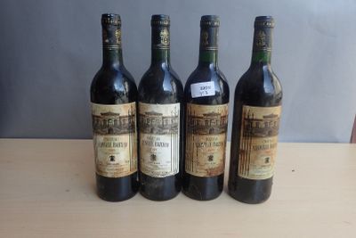 four bottles of wine are lined up on a table