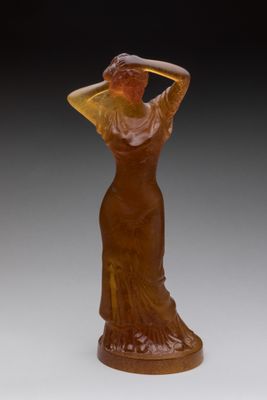 statue of a woman in a brown dress with a hat on her head