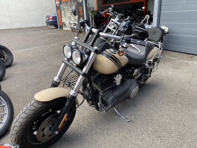 des motos garées devant un immeuble, avec un garage en arrière-plan