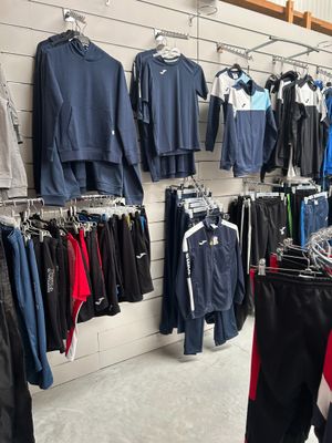 beaucoup de vêtements suspendus à une étagère dans un magasin