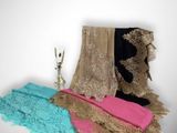 three pieces of clothing are sitting on a table next to a candle