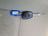 une photo d'une clé de voiture et d'une télécommande posées sur le siège d'une voiture