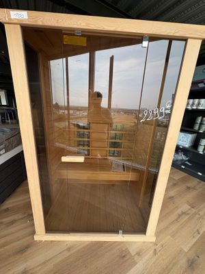 un sauna en bois avec une porte vitrée au milieu de la pièce
