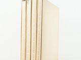 three books stacked on top of each other on a white surface