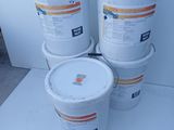 several buckets of paint sitting on top of a white table