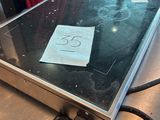 un ordinateur portable posé sur une table, sur lequel est collé un autocollant