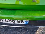 a close up of a green car with a number plate on it