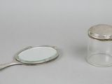 a small glass jar with a mirror and a spoon