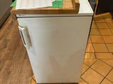 a white refrigerator in a kitchen with a wooden counter top