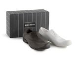 two pairs of men ' s shoes sitting next to a box of shoes
