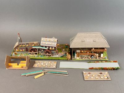 une petite maquette de maison et quelques crayons