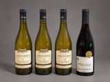 three bottles of wine are lined up on a table