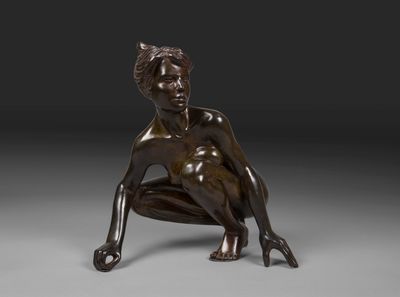 une statue en bronze représentant une femme assise à genoux