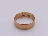 a close up of a gold ring with writing on it