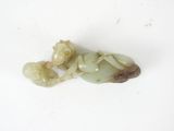 a small jade figurine of a baby on a white surface