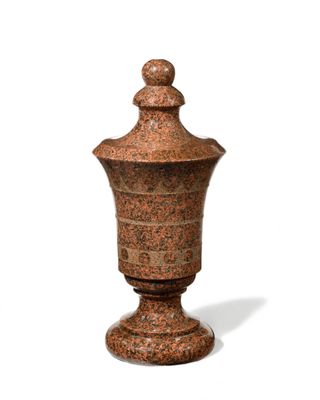 a small vase with a lid sitting on a white surface