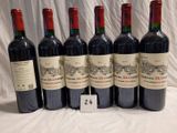 six bouteilles de vin rouge sont alignées sur une table